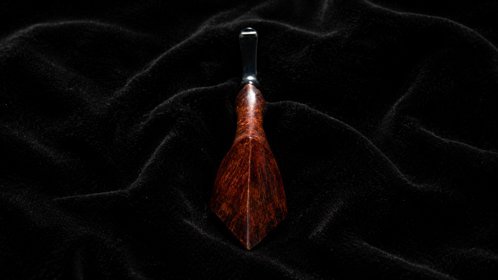 A handmade briar pipe by Aldan Karanovich resting on black velvet